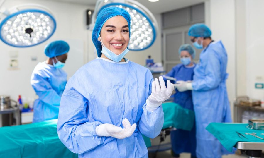 portrait-female-woman-nurse-surgeon-staff-member-dressed-surgical-scrubs-gown-mask-hair-net-hospital-operating-room-theater (1)